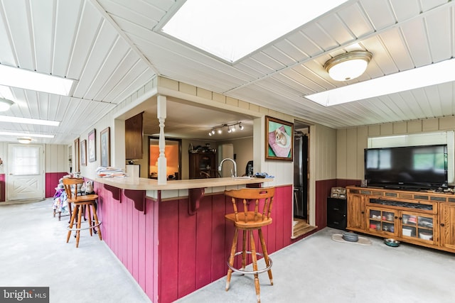 kitchen featuring a skylight, open floor plan, and a kitchen breakfast bar