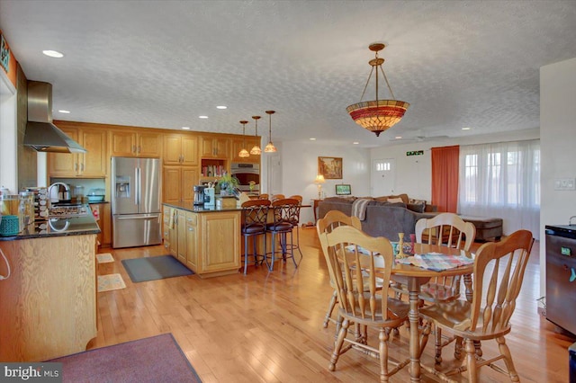 dining area featuring light wood-type flooring, a textured ceiling, and recessed lighting