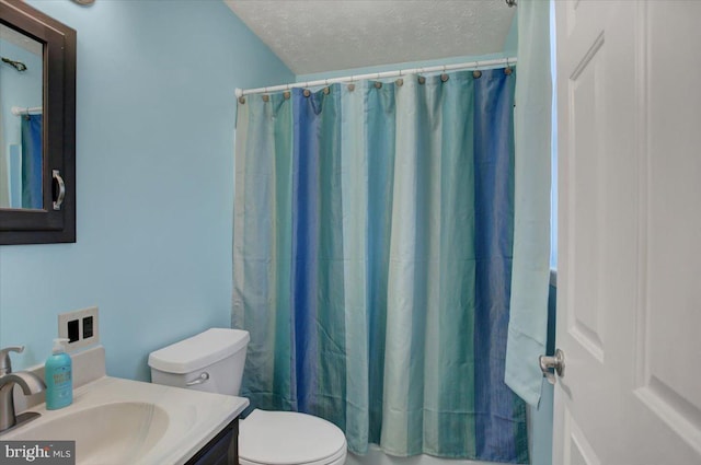 bathroom featuring a textured ceiling, vanity, and toilet