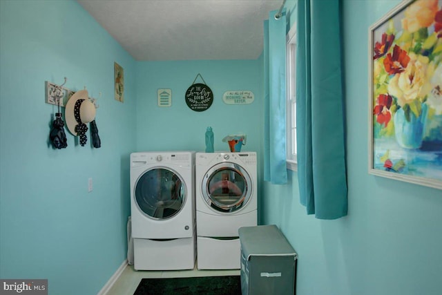 laundry area featuring a textured ceiling, laundry area, independent washer and dryer, and baseboards