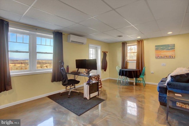 office space with a paneled ceiling, baseboards, and a wall mounted air conditioner