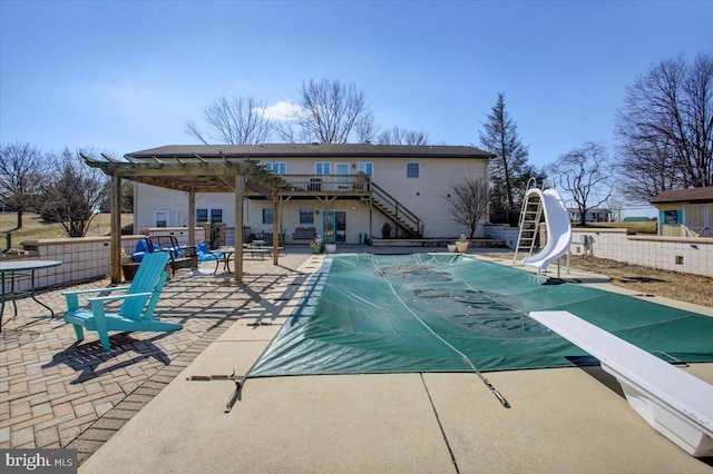 view of pool featuring a fenced in pool, stairway, a patio area, fence, and a water slide