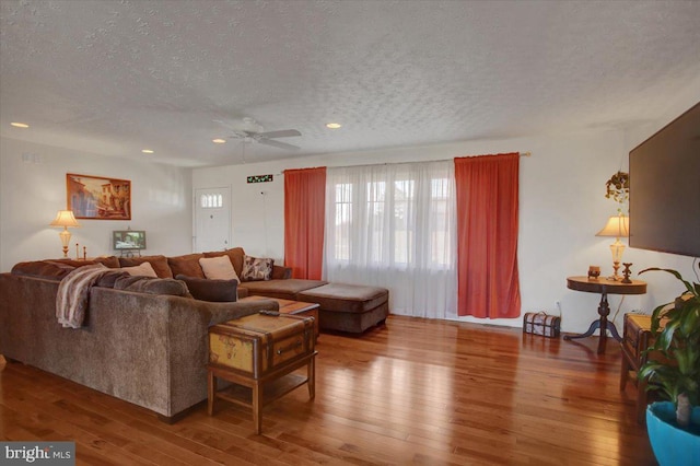 living room featuring a textured ceiling, ceiling fan, hardwood / wood-style flooring, and recessed lighting