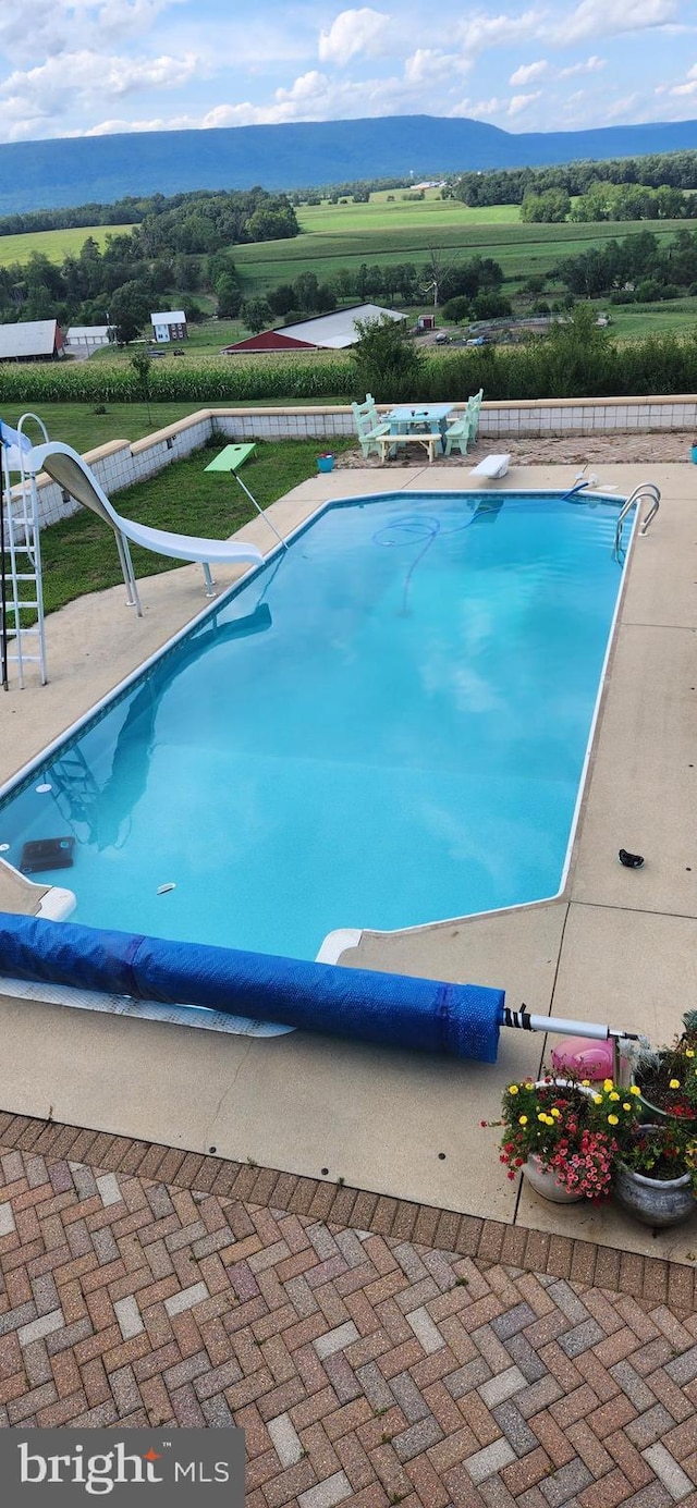 view of swimming pool with a fenced in pool, a patio, and a diving board