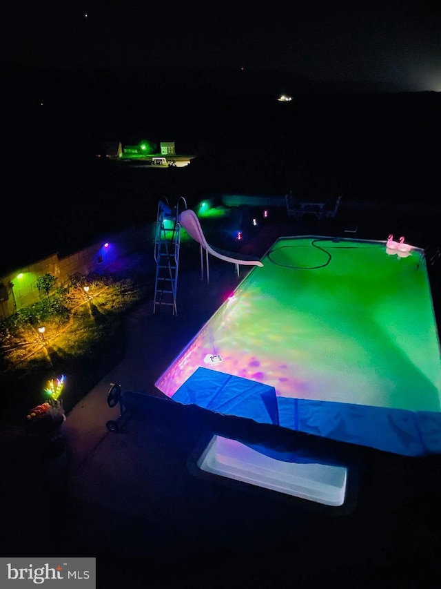 view of pool at twilight