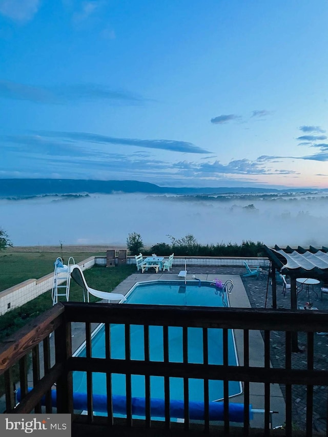 view of pool featuring a fenced in pool and a water slide