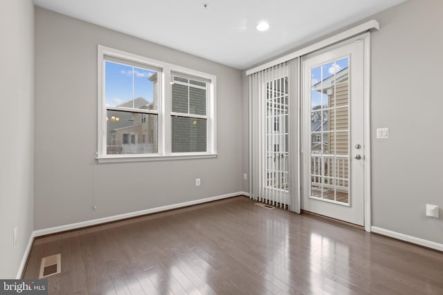 empty room with visible vents, baseboards, and wood finished floors