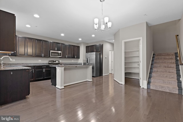 kitchen featuring a sink, appliances with stainless steel finishes, dark wood-style floors, and dark brown cabinets