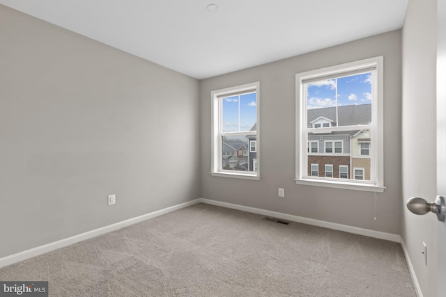 carpeted empty room with baseboards and visible vents