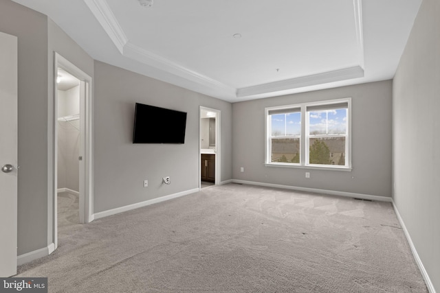 interior space featuring visible vents, crown molding, baseboards, light colored carpet, and a tray ceiling