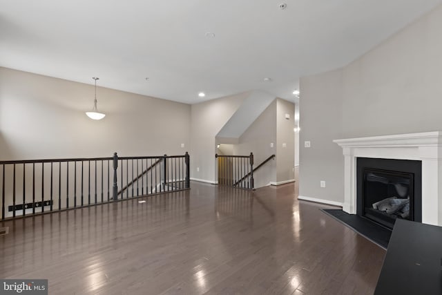 living room with a glass covered fireplace, baseboards, wood finished floors, and recessed lighting