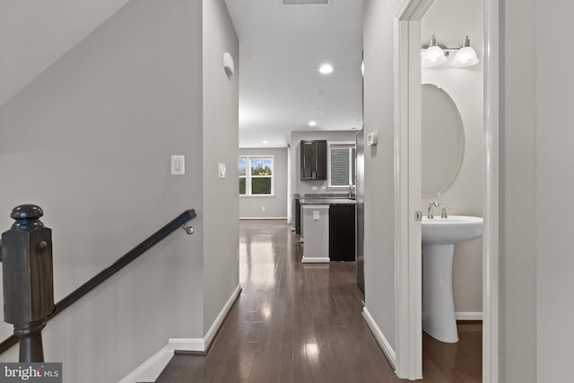 corridor featuring an upstairs landing, recessed lighting, dark wood-type flooring, and baseboards