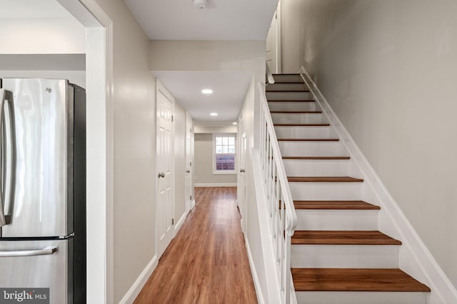 staircase featuring recessed lighting, baseboards, and wood finished floors