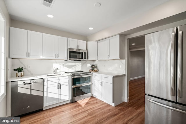 kitchen featuring light wood-style floors, visible vents, stainless steel appliances, and light countertops