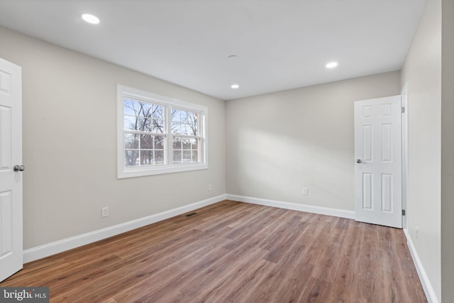 unfurnished bedroom featuring baseboards, wood finished floors, and recessed lighting