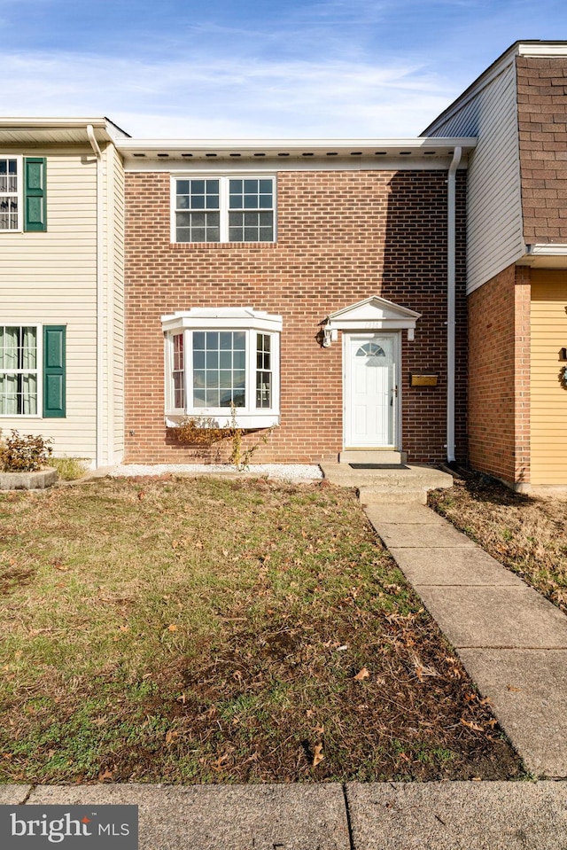 multi unit property featuring brick siding and a front lawn