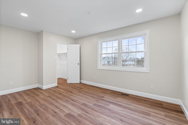 unfurnished bedroom featuring recessed lighting, wood finished floors, visible vents, and baseboards