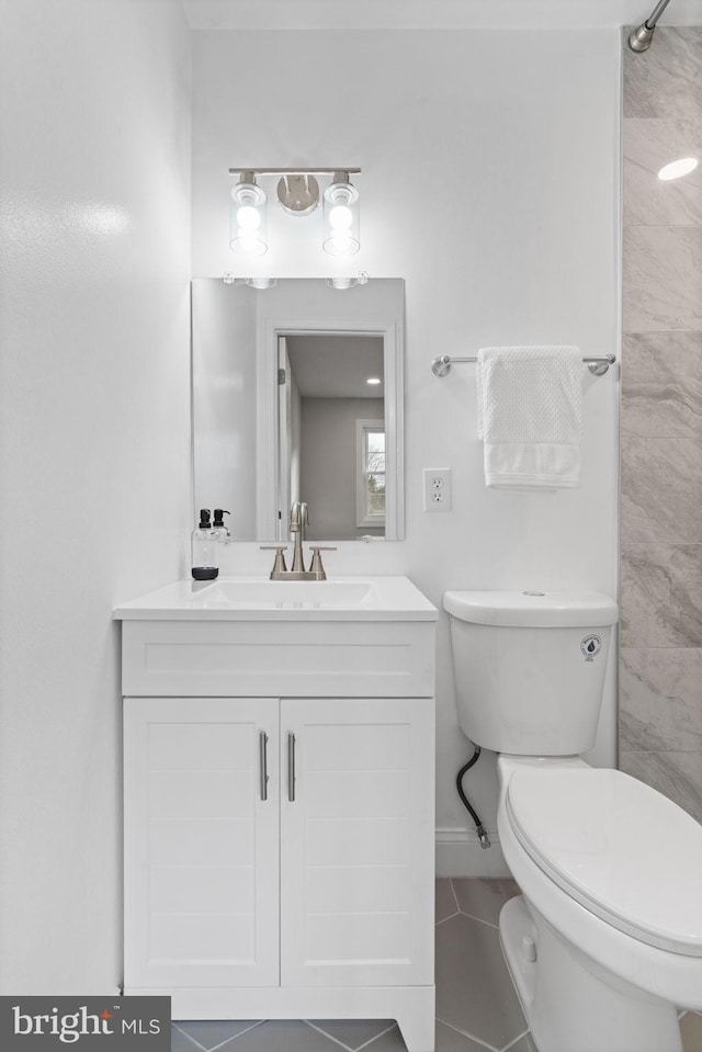 bathroom with tile patterned flooring, vanity, and toilet