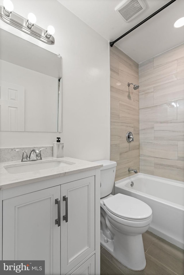 full bath featuring visible vents, toilet, tub / shower combination, vanity, and tile patterned floors