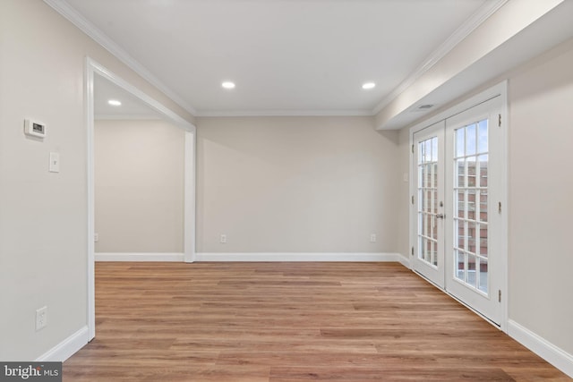 spare room with baseboards, french doors, light wood-style flooring, and crown molding