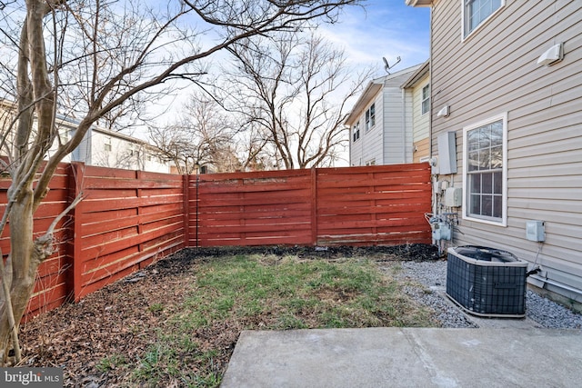 view of yard featuring a fenced backyard, a patio, and central AC