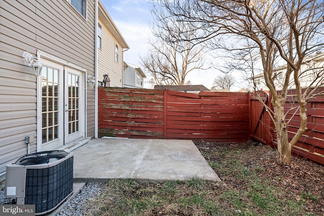 view of patio featuring central AC, french doors, and a fenced backyard