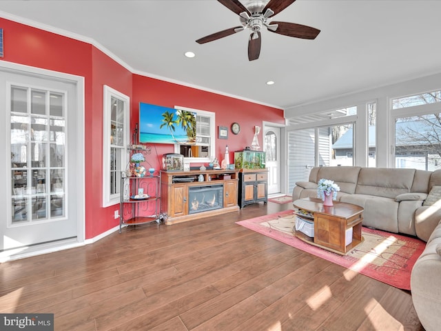 living room with baseboards, ornamental molding, wood finished floors, and recessed lighting