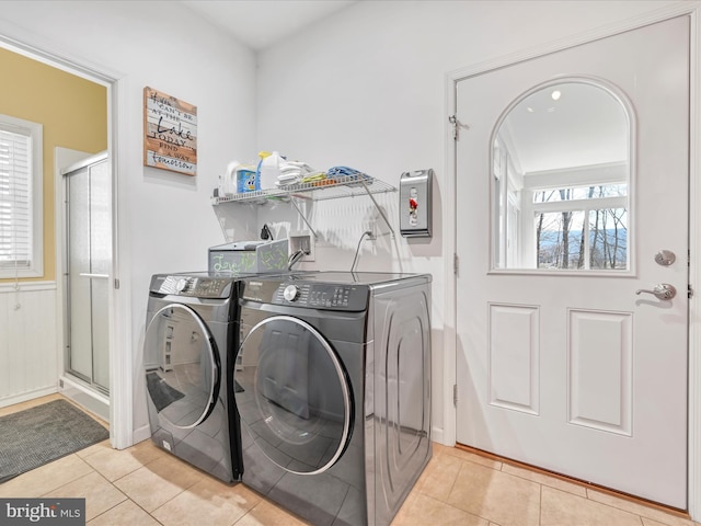 laundry room with laundry area, light tile patterned flooring, and washer and clothes dryer