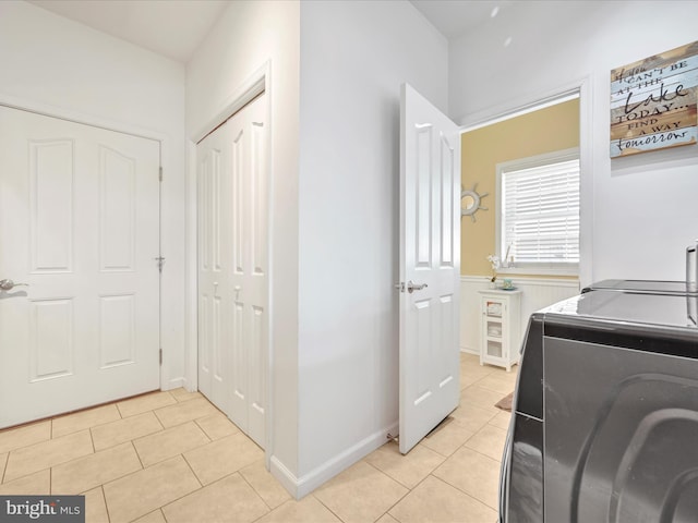 clothes washing area featuring laundry area, independent washer and dryer, baseboards, and light tile patterned floors