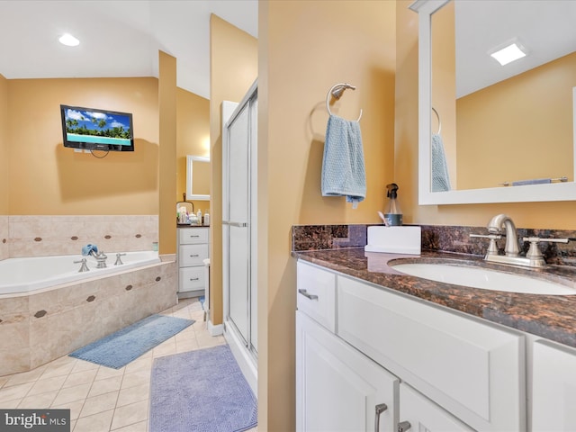 bathroom with lofted ceiling, a garden tub, vanity, tile patterned floors, and a stall shower