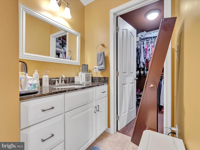 bathroom featuring a spacious closet, vanity, and tile patterned floors