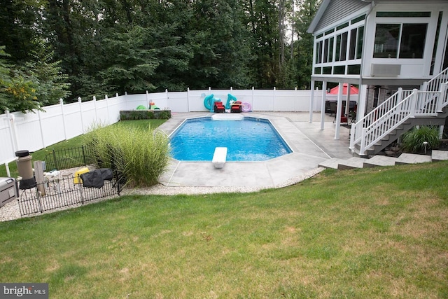 view of pool with a patio, a fenced backyard, stairs, a yard, and a diving board