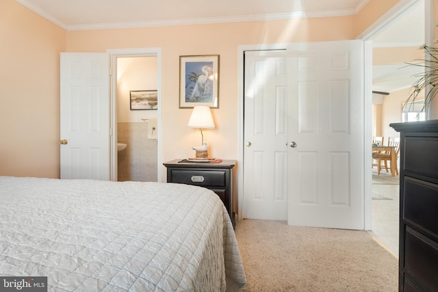 bedroom featuring a closet, crown molding, and ensuite bathroom