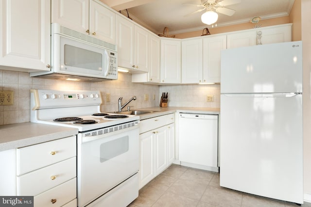 kitchen featuring white appliances, a sink, light countertops, tasteful backsplash, and crown molding