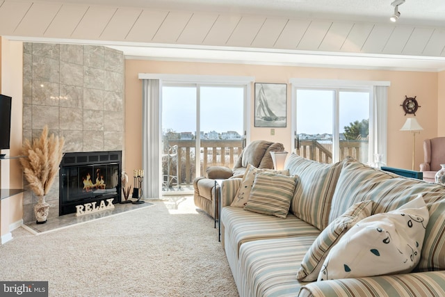 carpeted living area with a tile fireplace