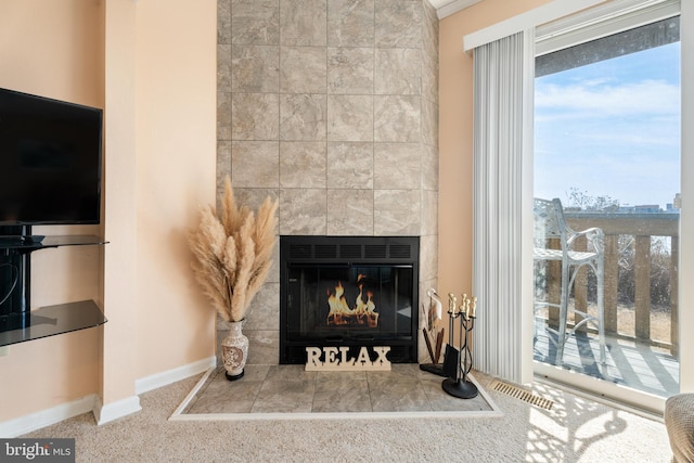 details with a tile fireplace, visible vents, and baseboards