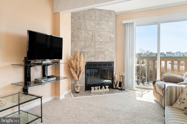 living area featuring carpet floors, a large fireplace, baseboards, and ornamental molding