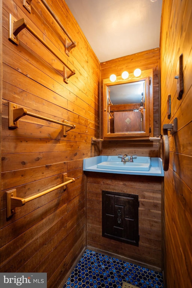 bathroom with tiled shower, wooden walls, and vanity