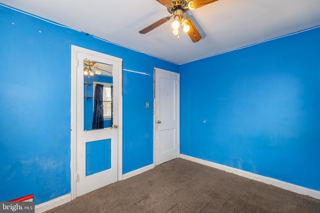 carpeted empty room with ceiling fan and baseboards