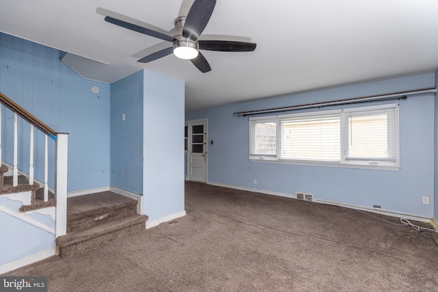 unfurnished living room with carpet floors, a ceiling fan, visible vents, baseboards, and stairway