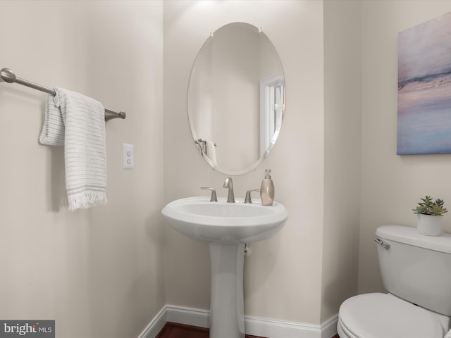 bathroom featuring toilet and baseboards