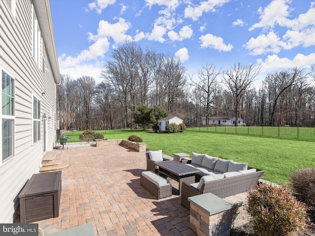 view of patio / terrace featuring an outdoor living space, a shed, an outbuilding, and a fenced backyard