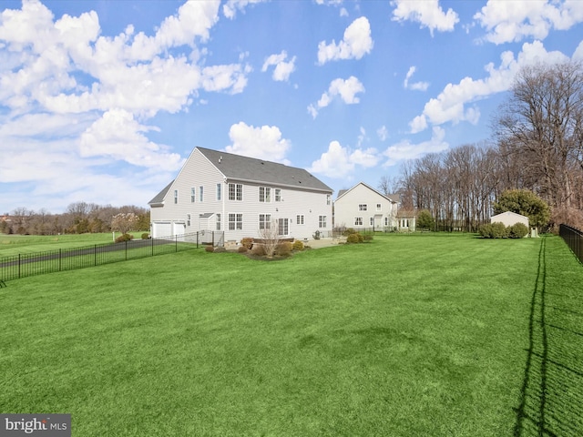 back of house featuring a garage, a lawn, and a fenced backyard