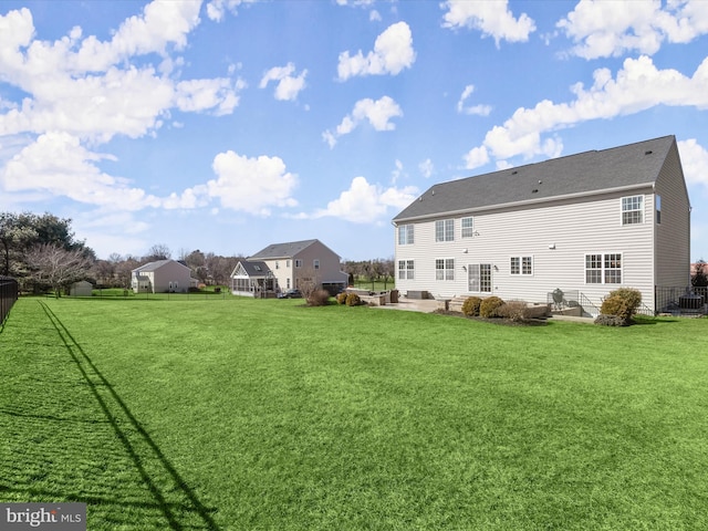 rear view of property featuring a yard, fence, and a patio area