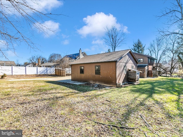 rear view of property with a lawn and fence