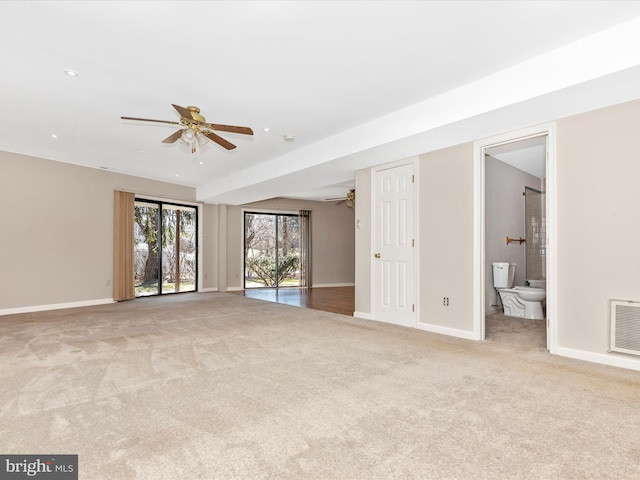 carpeted spare room featuring baseboards, visible vents, and a ceiling fan