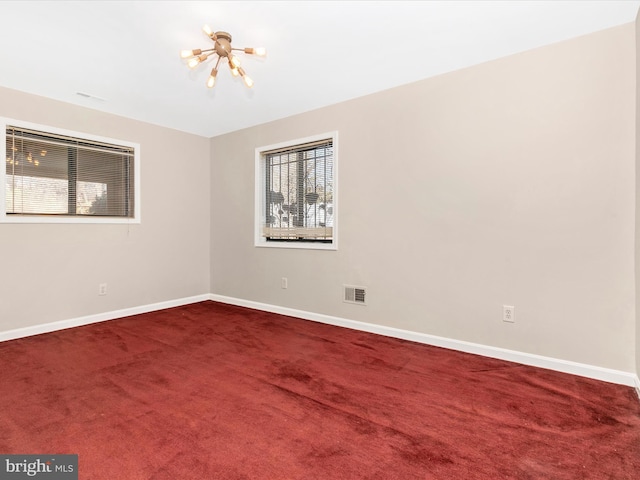 unfurnished room featuring carpet, visible vents, a notable chandelier, and baseboards