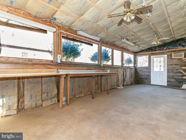 miscellaneous room with concrete flooring, an AC wall unit, ceiling fan, and lofted ceiling