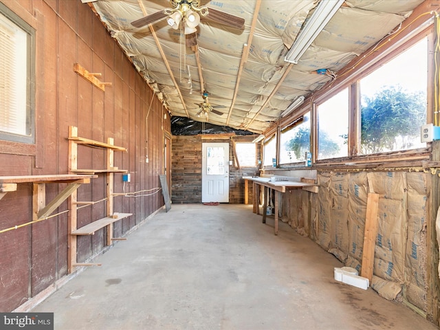 miscellaneous room with lofted ceiling, unfinished concrete flooring, and ceiling fan