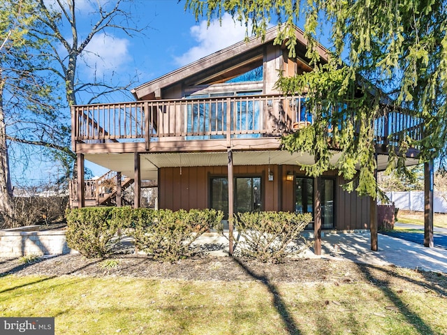 back of house featuring a deck and stairs